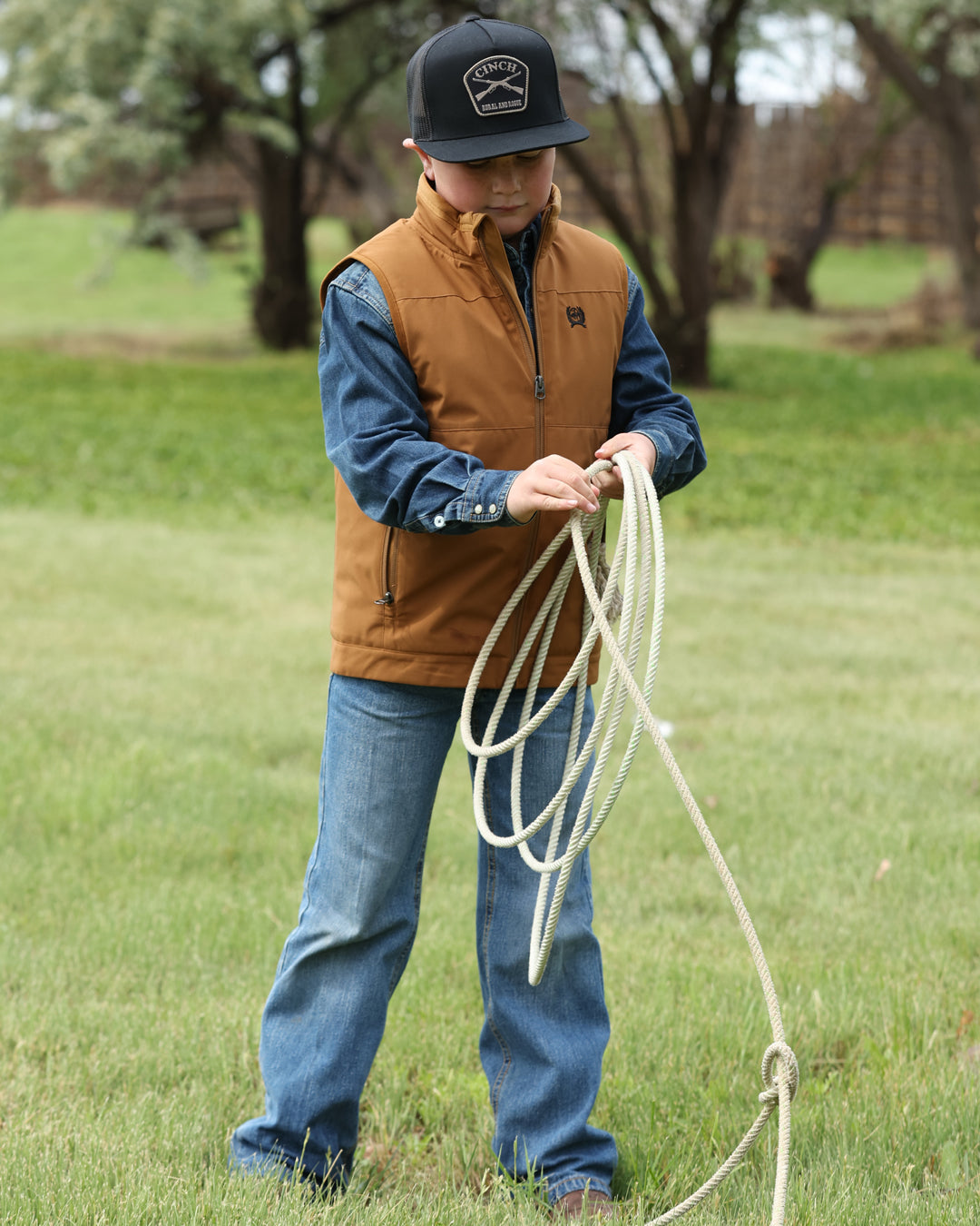Person holding a lasso in a grassy outdoor setting